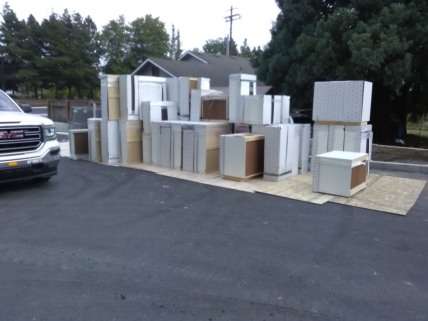 Rows of new cabinets staged in a parking lot for a condo building